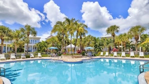 A swimming pool surrounded by palm trees and lounge chairs, with a clear blue sky. - Oceanside Anglers Reef Home+Beach, Pool and Kayaks (Islamorada)