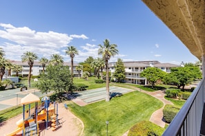 Children can play on the playground with a slide and climbing structures set amidst a well-maintained lawn.