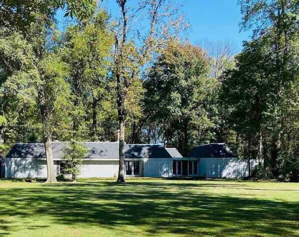 A row of cabins with a grassy lawn and trees in the background. - Spacious Hideaway | 5 bds, 3 ba (Greenville)