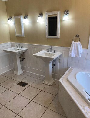 A bathroom with two sinks, a bathtub, and a window. - Spacious Hideaway | 5 bds, 3 ba (Greenville)