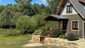 Une maison à deux étages avec un escalier en pierre menant à une terrasse en bois.