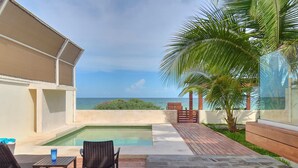A pool area with a view of the ocean, wooden deck, and seating. - Casa Kux  -  Yucatan Home Rentals (Chicxulub Puerto)