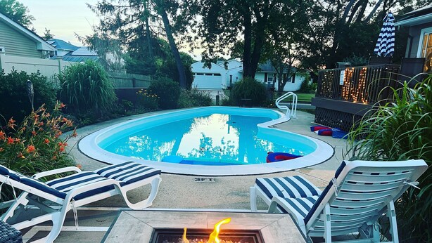 A swimming pool with lounge chairs and a fire pit. - 3 Bedroom Mimosa Pool Oasis, Sleeps 8, Outdoor Shower &Hot Tub.Dog & EV Friendly (Cape May)