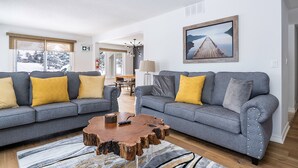 A living room with two grey sofas, yellow cushions, a wooden coffee table, and a framed picture on the wall. - Blue Mountain (The Blue Mountains)