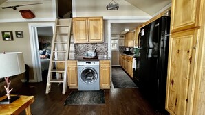 Una cocina compacta con muebles de madera, lavadora y refrigerador.