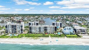A coastal hotel with multiple buildings, a beach, and a marina. - Luxury condo on the beach  (Naples)