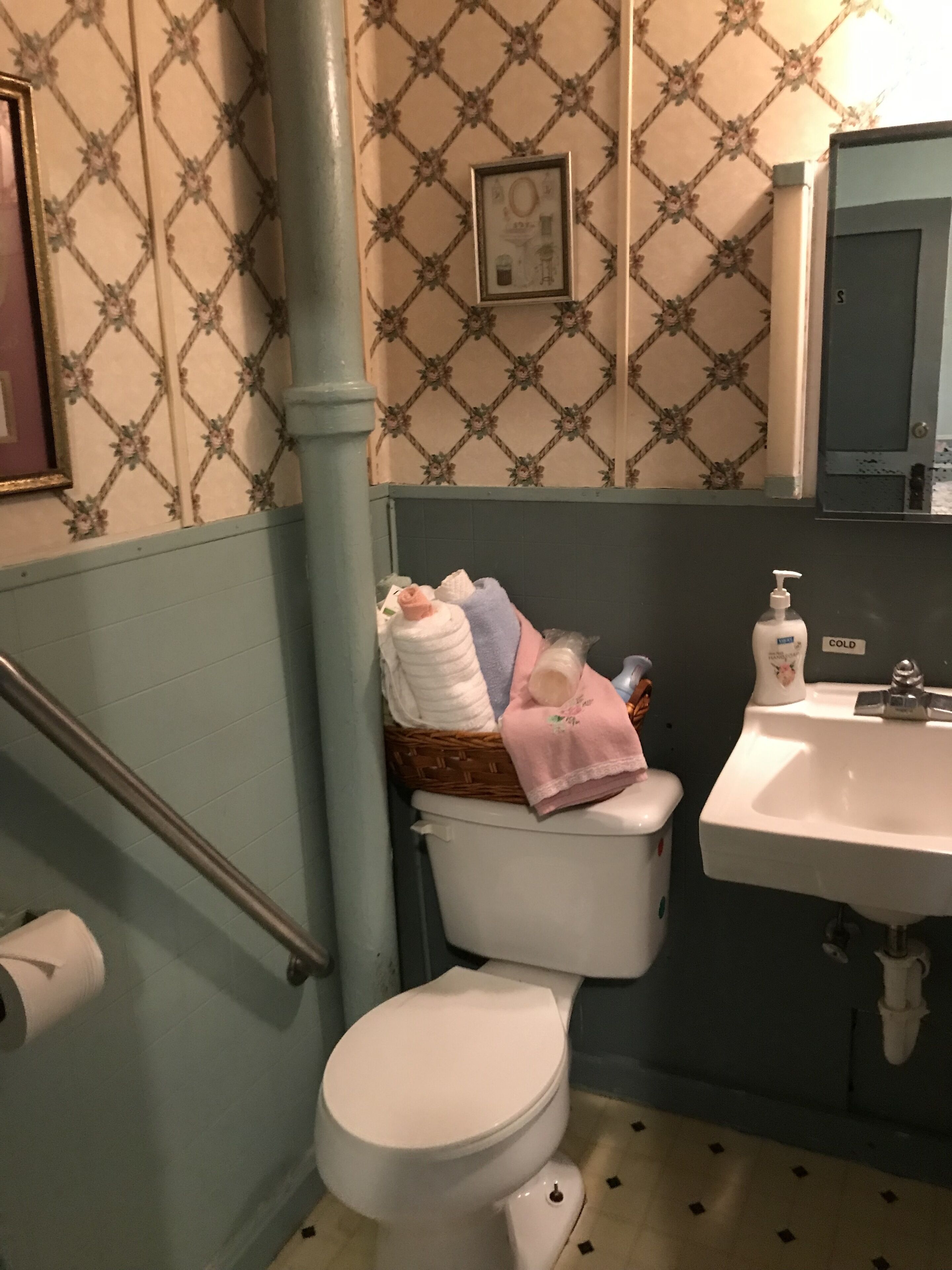 A bathroom with a toilet, a sink, and a shower area.