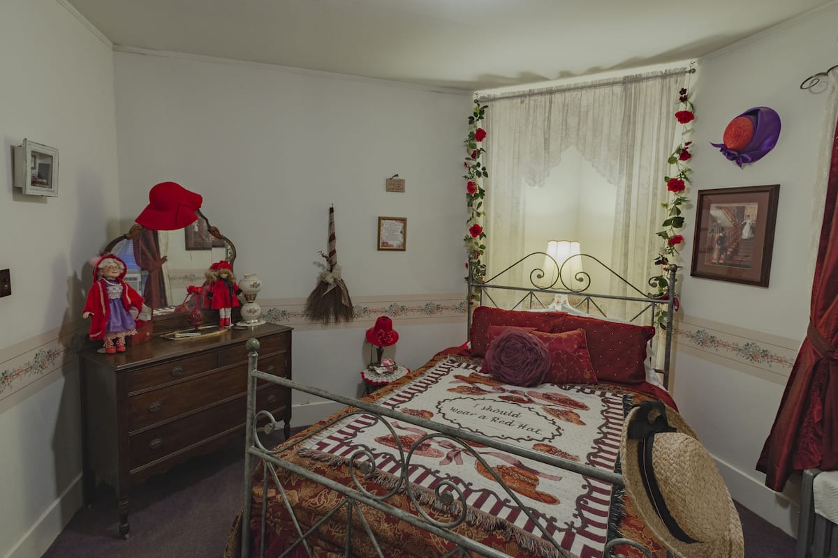 A bedroom with a bed, dresser, and a mirror.