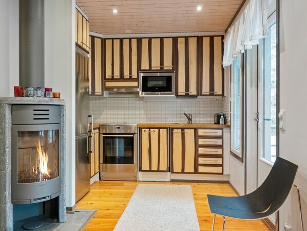 Een koelkast, een magnetron, een vaatwasser, kookgerei, borden en bestek