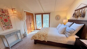 A bedroom with a bed, bedside table, dresser, and a wall-mounted mirror. - Red rock views ♦ Private access to the forestry ♦ The perfect romantic escape (Sedona)