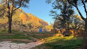 A landscaped garden with a stone pathway, brick borders, and a wooden fence. - Red rock views ♦ Private access to the forestry ♦ The perfect romantic escape (Sedona)