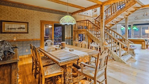 A wooden dining table with chairs, a staircase, and a chandelier. - River Access, Mtn Views! All-Season Cullowhee Base (Cullowhee)
