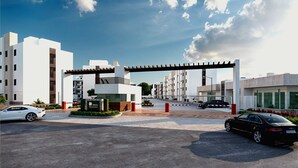 A modern building with a covered entrance, a parking area with cars, and a clear sky. - Bright & Relaxing Full Apartment (Cancun)