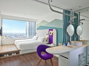 A modern hotel room with a large window, a bed, a desk, a chair, and a bathroom with a sink and mirror. - Tru by Hilton Bac Giang City Centre (Bac Giang)