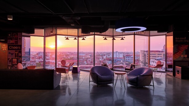 Un interior moderno con un amplio ventanal que ofrece vistas de la ciudad al atardecer.