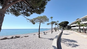 A pebble beach with trees and a clear blue sky. - 3P - SANDY BEACH - A/C - swimming pool - Wifi (Villeneuve-Loubet)