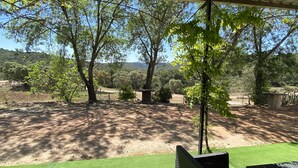 An outdoor patio area with a view of a hilly landscape.