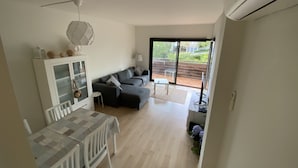 A modern living room with a sofa, a dining table with chairs, and a glass cabinet. - Private property in front of Boadella beach (Lloret de Mar)