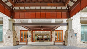 A covered entrance with stone walls and wooden beams, leading to an indoor seating area with tables and chairs. - 2 Bedroom 2 Bathroom Swim Out Apartment in the Temple resort Palm Cove (Palm Cove)