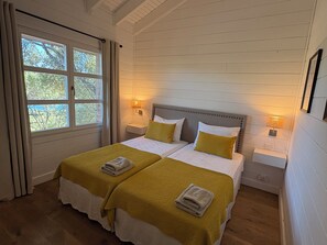 A double room with two beds, a window, and bedside lamps.