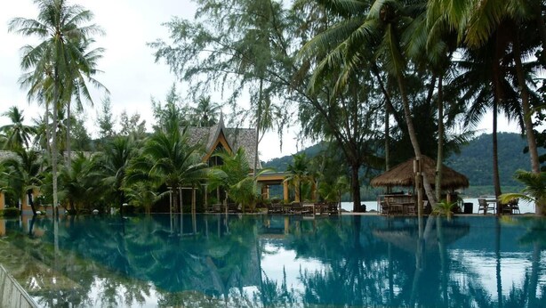 A clear swimming pool surrounded by palm trees and a thatched-roof structure. - Villa Banromyen Siamroyalview 70mtrs to Beach (Ko Chang)