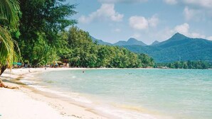 A beach with clear turquoise water, white sand, and lush green trees. - Villa Banromyen Siamroyalview 70mtrs to Beach (Ko Chang)