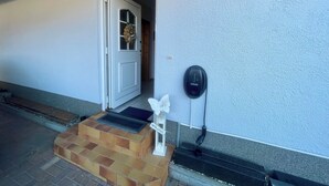 Une entrée de maison avec une porte blanche, une boîte aux lettres et une marche en briques menant à la porte.