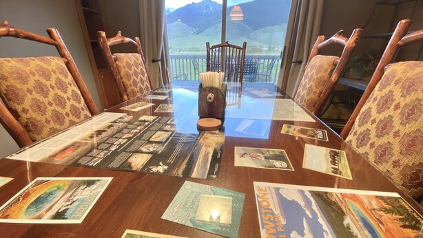 A conference table with a glass top displaying various Yellowstone National Park brochures.