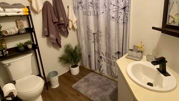 Een bad/douchecombinatie, een haardroger, handdoeken