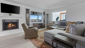 Un salon moderne avec une cheminée, un téléviseur à écran plat, un canapé et une table basse.