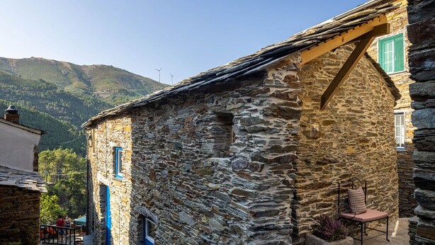 A stone building with a sloped roof, a small window, and a bench outside. - Contemporary styled studio (Piódão)