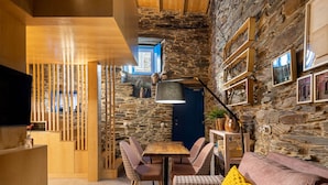 A cozy interior with a stone wall, wooden furniture, and a blue door.