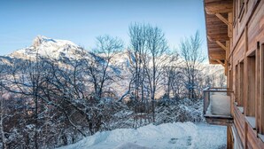 A wooden cabin with a snow-covered balcony overlooking a mountainous landscape. - Chalet Woodman - alpine base for 14, spa and summer pool - OVO Network (Saint-Gervais-les-Bains)