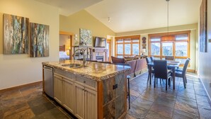 A spacious kitchen with a granite countertop, a dishwasher, and a dining area with a table and chairs. - Spacious Top-Floor 3-bed Springs Condo: 5 minute walk to gondola and restaurants (Keystone)