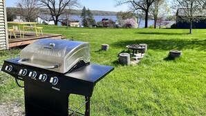 A backyard with a black Char-Broil grill, a wooden deck, and a picnic table. - Peaceful River Retreat with Fireplace & Panoramic Views (Cementon)