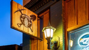 A wooden building with a sign reading "ORE HOUSE INN" and a neon sign above the entrance. - Merlin's Bunkhouse at the Ore House Inn (New Castle)