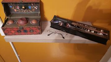 A wooden shelf with a decorative box containing three brown objects and a Harry Potter-themed wand.
