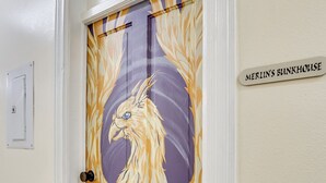 A door with a mural of a mythical creature, a sign reading "Merlin's Bunkhouse," and a doormat with a paw print. - Merlin's Bunkhouse at the Ore House Inn (New Castle)