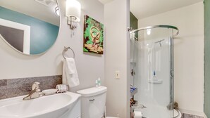 A bathroom with a sink, toilet, and glass-enclosed shower. - Merlin's Bunkhouse at the Ore House Inn (New Castle)