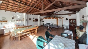 Un comedor rústico con una mesa de madera y bancos, una bicicleta y un soporte para bicicletas.