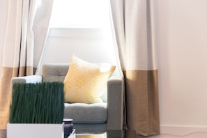 Relax in this stylish living room with a comfortable sofa, decorative plant, and large window.