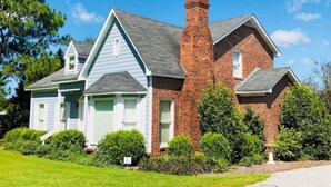 A two-story house with a brick chimney, a blue front, and a well-maintained lawn. - Rose Ellen’s Country Estate10% saving on 30 day stays  (Leesburg)