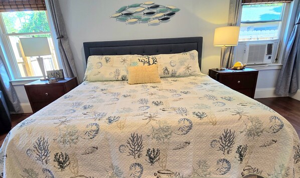 A bed with a floral bedspread, a clock, and a wall decoration.