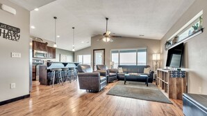 A spacious living area with a kitchen, a dining area, and a seating area with a sofa and chairs.