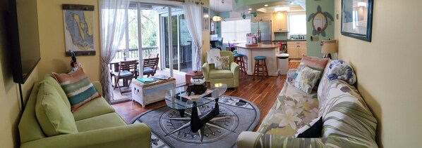A living room with a sofa, a coffee table, and a dining area with chairs. - Direct water access to Charlotte Harbor and Gulf of Mexico with no bridges. (Bokeelia)