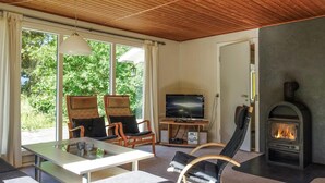 A cozy living room with a fireplace, a TV, and comfortable seating. - 2 bedroom stunning home in Aakirkeby (Aakirkeby)