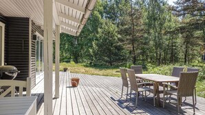 A wooden deck with outdoor furniture, a grill, and a potted plant. - 2 bedroom stunning home in Aakirkeby (Aakirkeby)