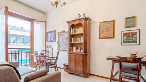 Ein gemütliches Wohnzimmer mit einer Holzregal, einem Essbereich mit Tisch und Stühlen sowie Kunstwerken an den Wänden.