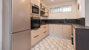 Una cucina moderna dotata di frigorifero, forno, microonde e lavello.
