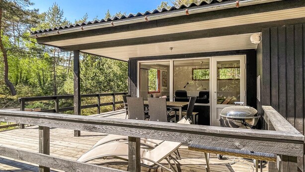 A wooden deck with outdoor seating and a covered area with a grill. - Amazing home in Nexø with WiFi (Nexø)